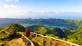 Hiker in a red jacket at the caldera on São Miguel island in the Azores
