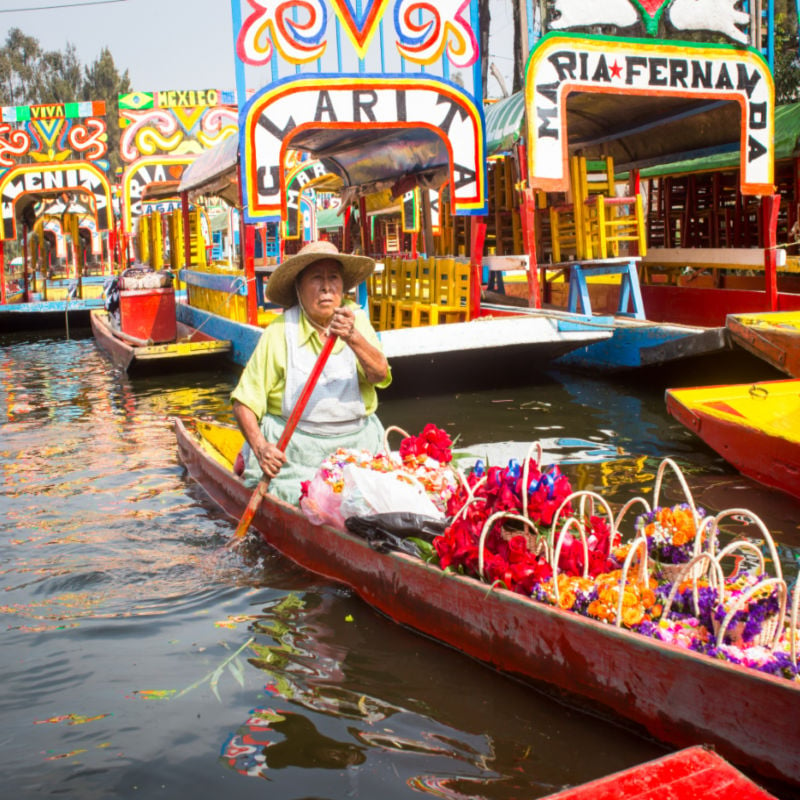 woman on colorful boat in mexico city 
