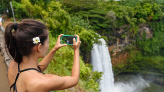 tourist at hawaii waterfall
