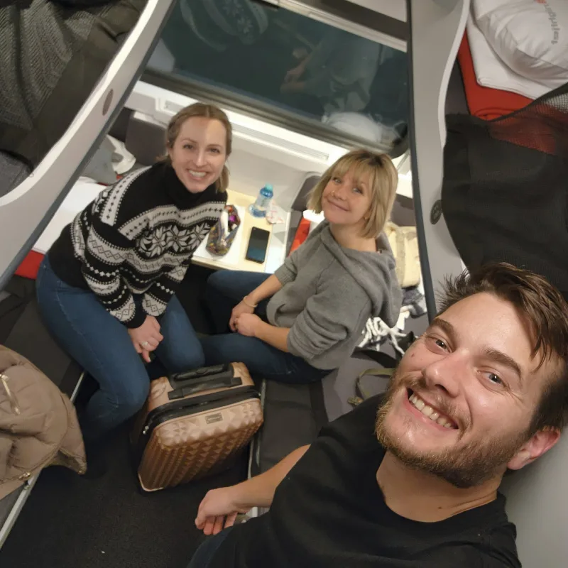 3 Travelers taking a selfie in a sleeper train cabin with 4 bunks