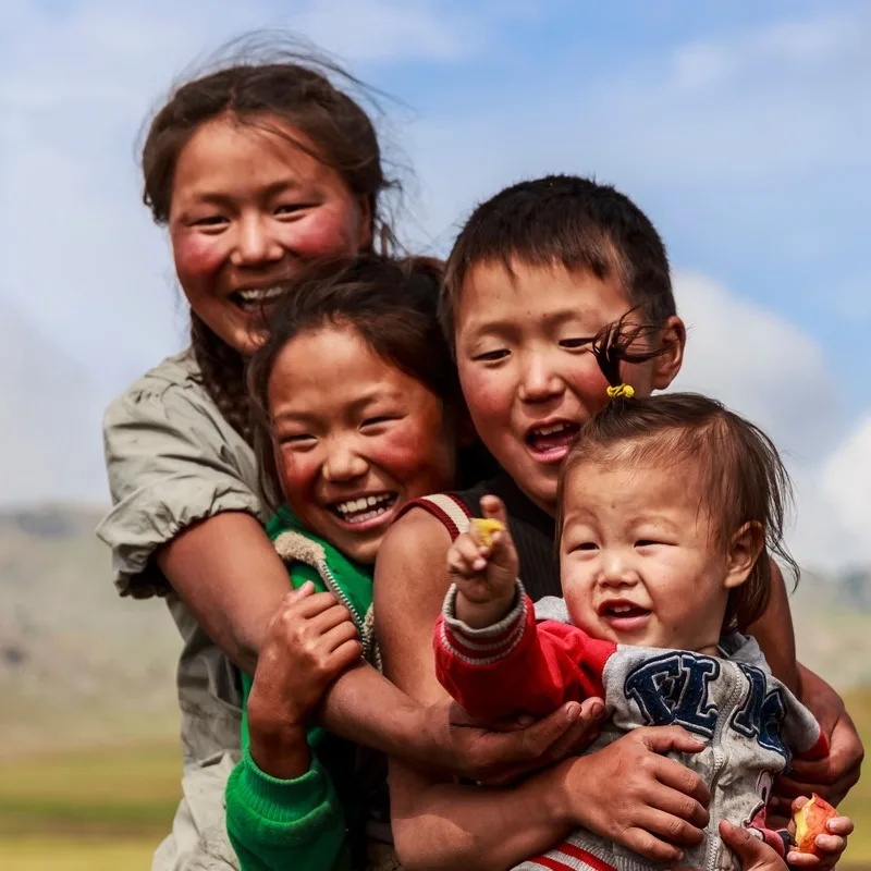 A Family Of Smiling Mongolian Nomads Photographed In Mongolia, Central Asia