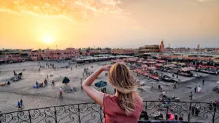 Female Tourist Photographing The Jamaa Elfna Market In Marrakech, Morocco