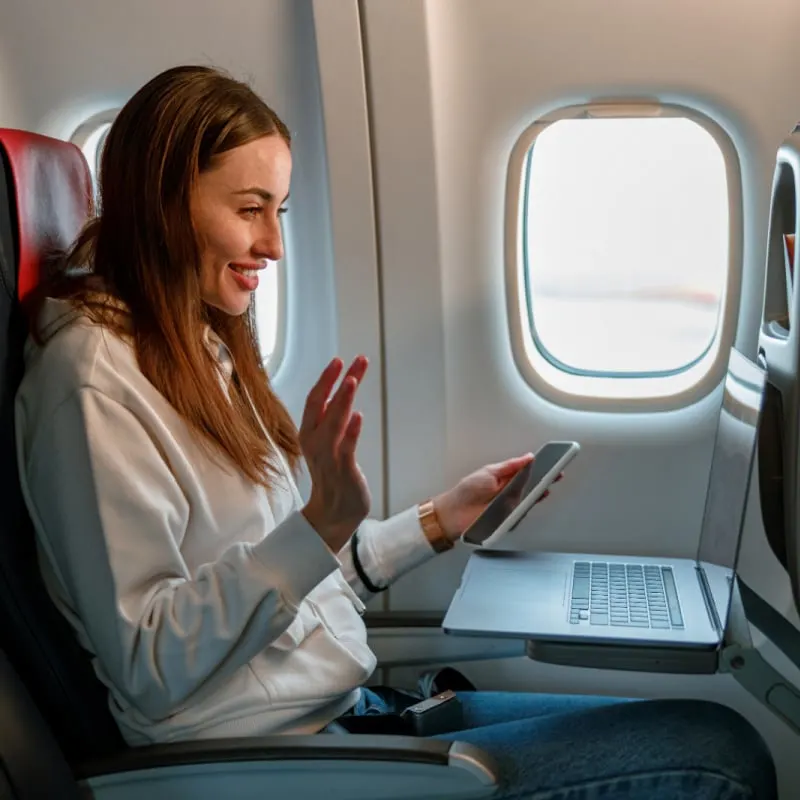 Woman Using Laptop and Cellphone on Flight