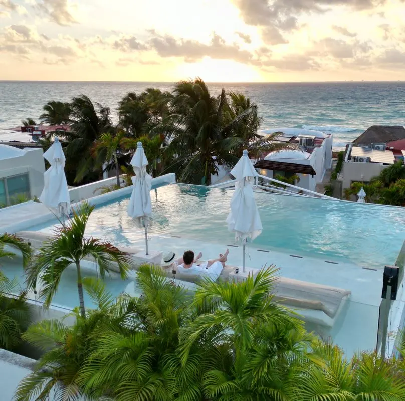 Man and woman on top of luxury villa in playa del carmen overlooking the ocean and sunset