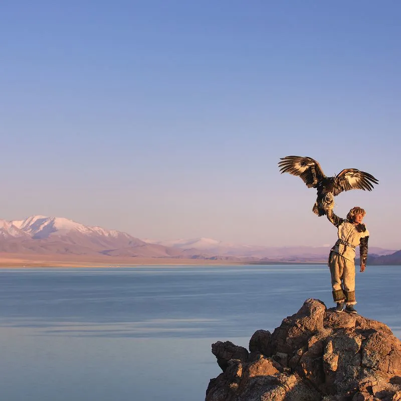 Mongolian Nomadic Person Holding Up An Eagle On A Mountaintop, East Asia