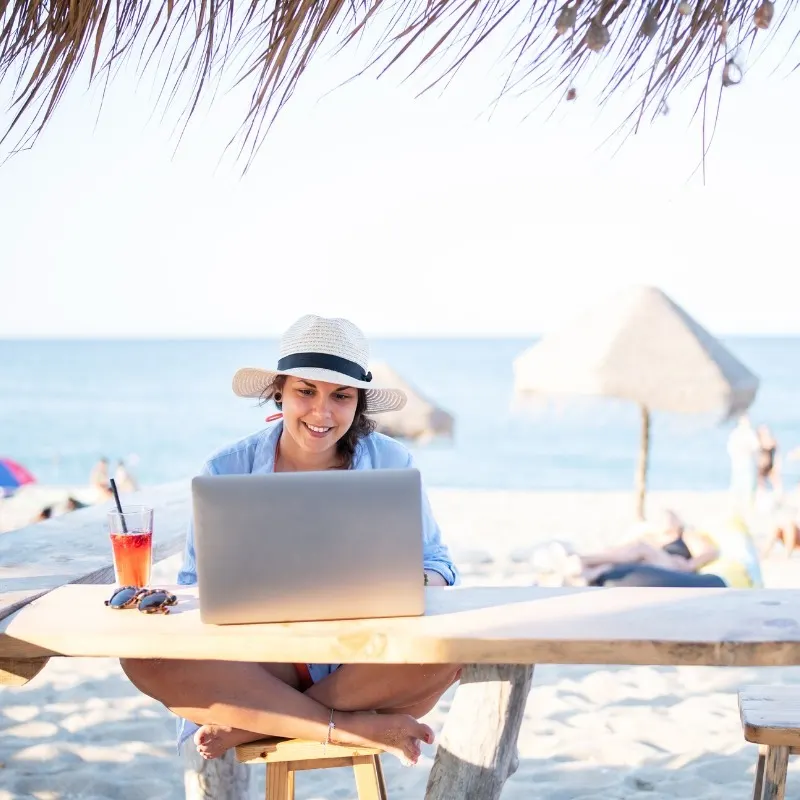 Remote Worker Working With A Computer On A Beach Location