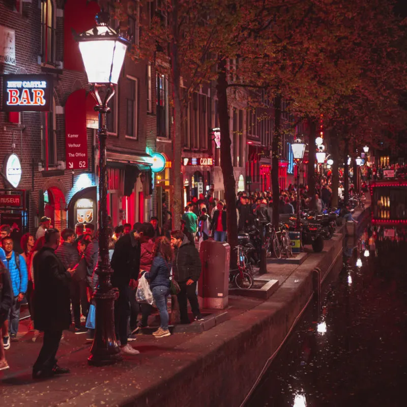 Crowd of international tourists walking on streets of Red Light District of Amsterdam in the Netherlands.