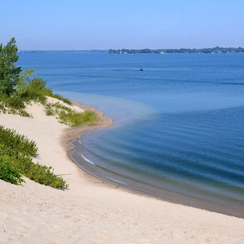 Sand dunes meeting blue water of Lake Ontario in Prince Edward County
