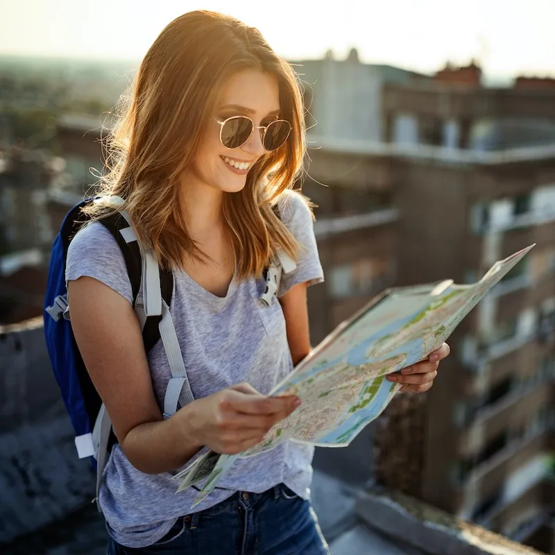 smiling woman observing map in Europe