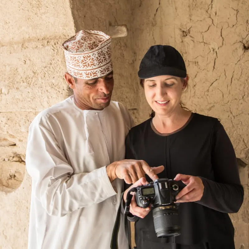solo female traveler with omani tour guide looking at camera in muscat oman