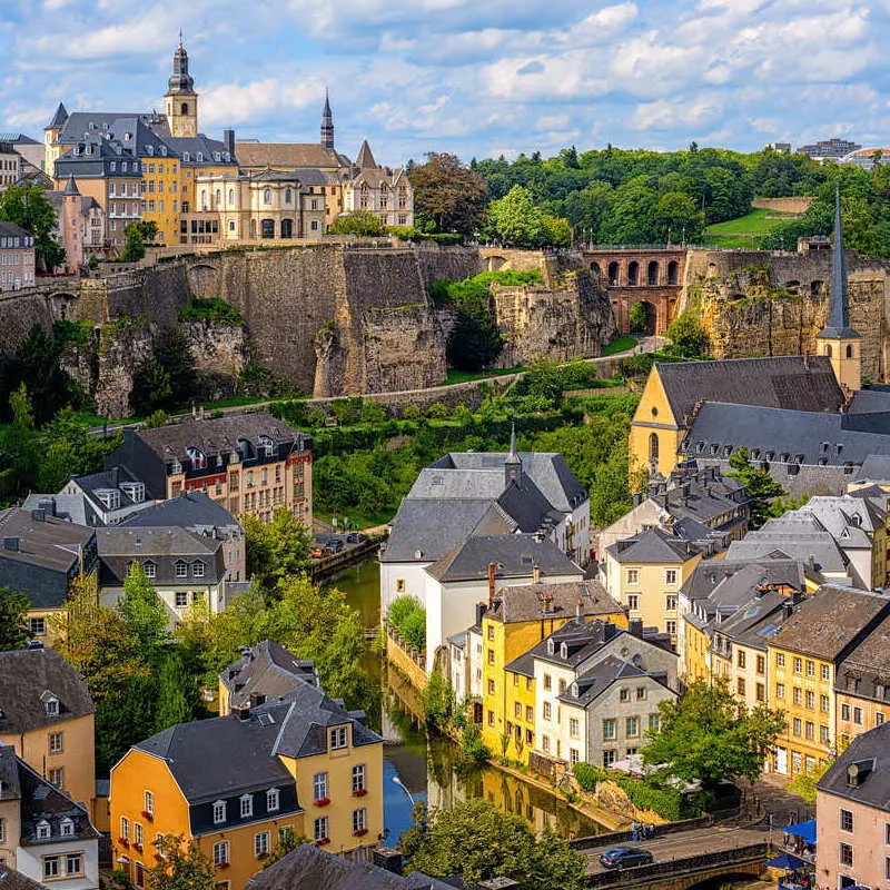 The Pastel Colored Houses Of The Grund In Luxembourg City's Old Town Seen From The Chemin De La Corniche, Luxembourg, Western Europe