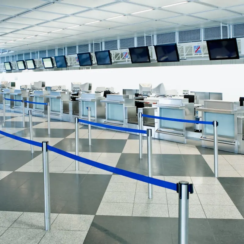 The public check-in area of an airport with crowd control barriers