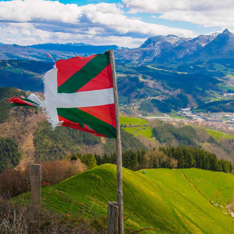 Torn Basque Flag Waving In The End Atop A Mountain In The Basque Country Countryside, Northern Spain, Southern Europe