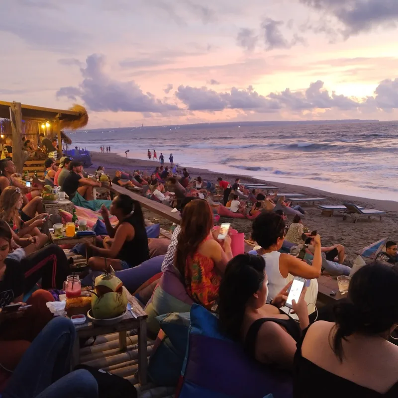 travelers gathered to admire sunset at the beach in Bali