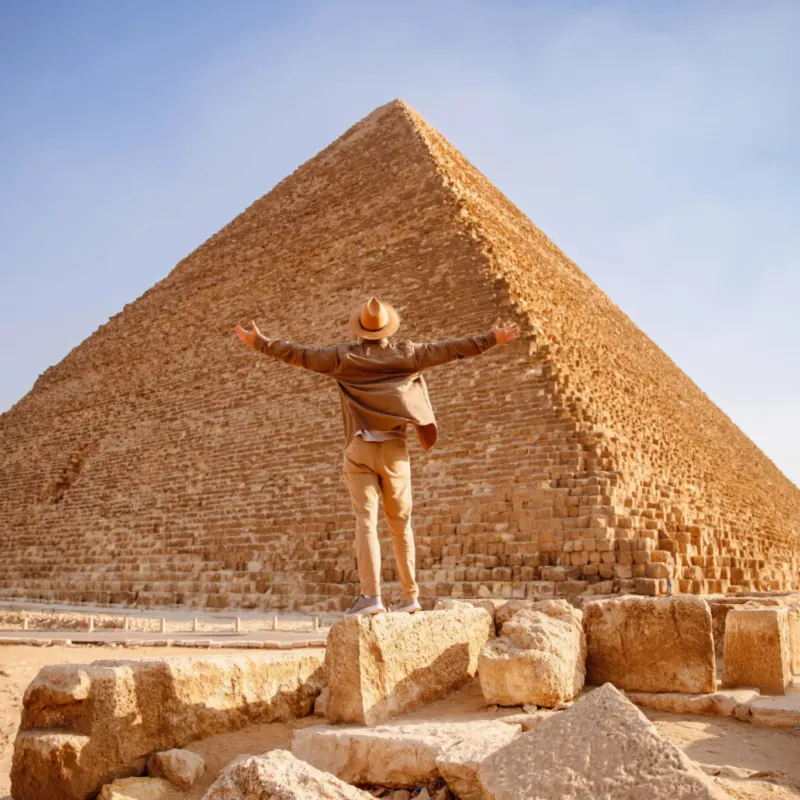 Travel man in hat stand background Egyptian pyramid sunset Giza Cairo, Egypt.