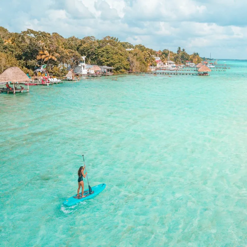 Woman Doing Paddle Boarding In Lake Bacalar, Quintana Roo, Mexico