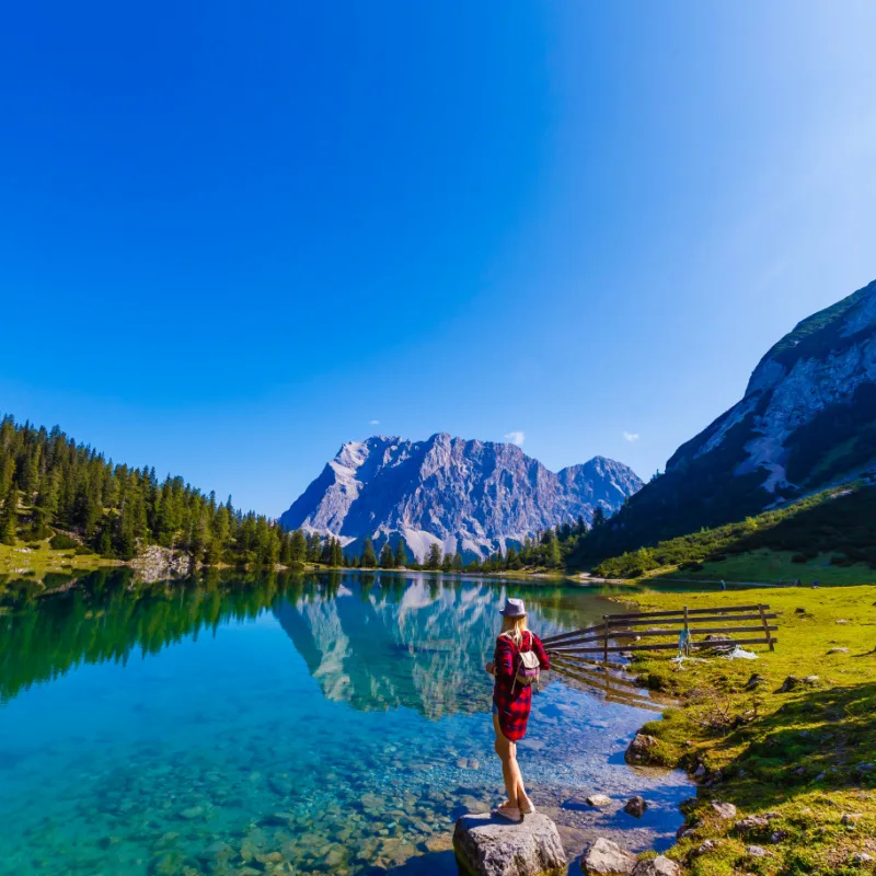 woman enjoying beauty of nature looking at mountain. Adventure travel, Europe. Woman stands on background with Alps austria copy