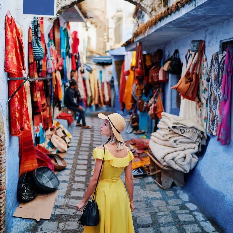 woman traveling alone in a yellow dress in chefchauen morocco